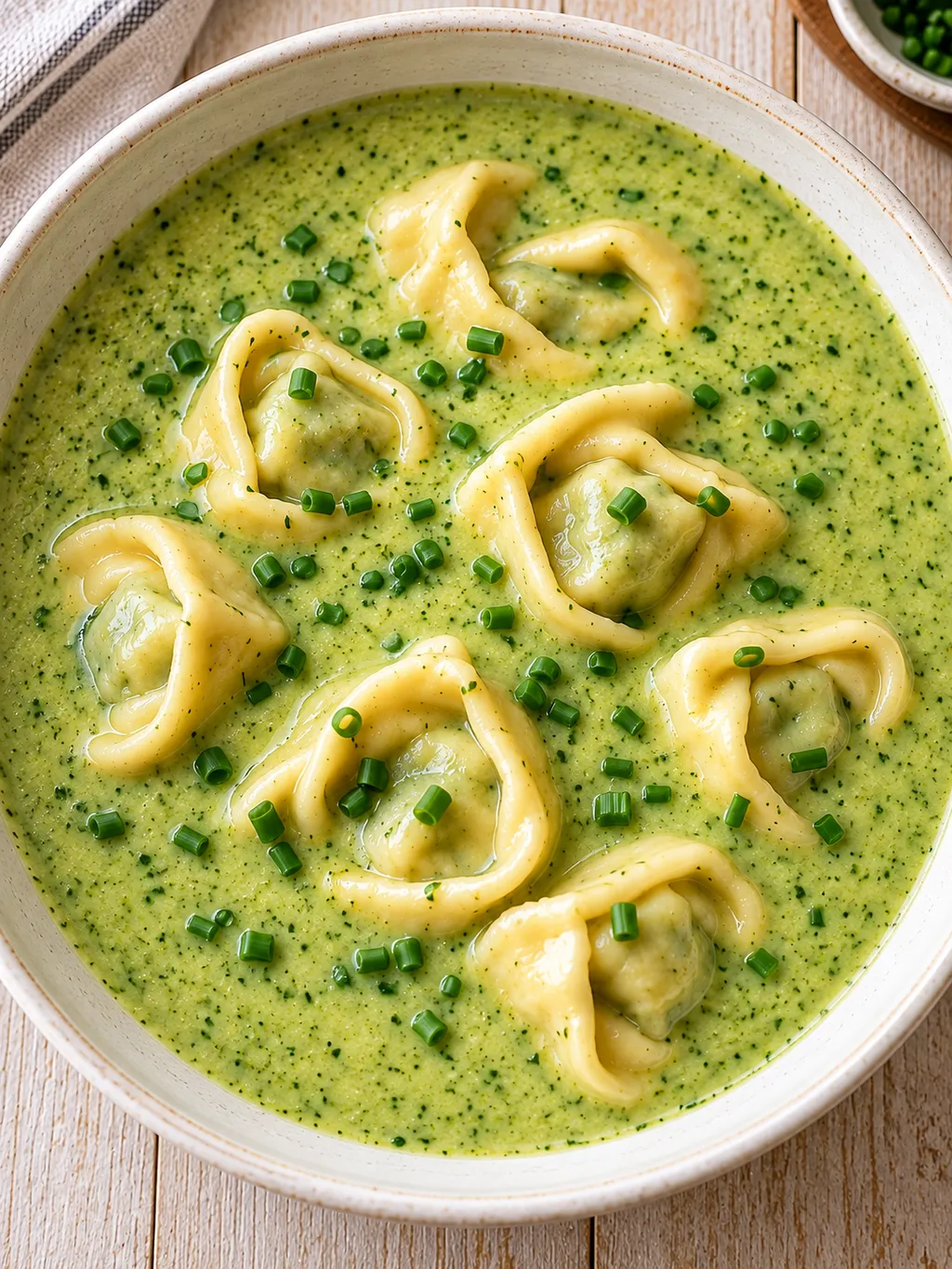 Brokkoli-Cremesuppe mit zarten Tortellini und fein geschnittenem Schnittlauch