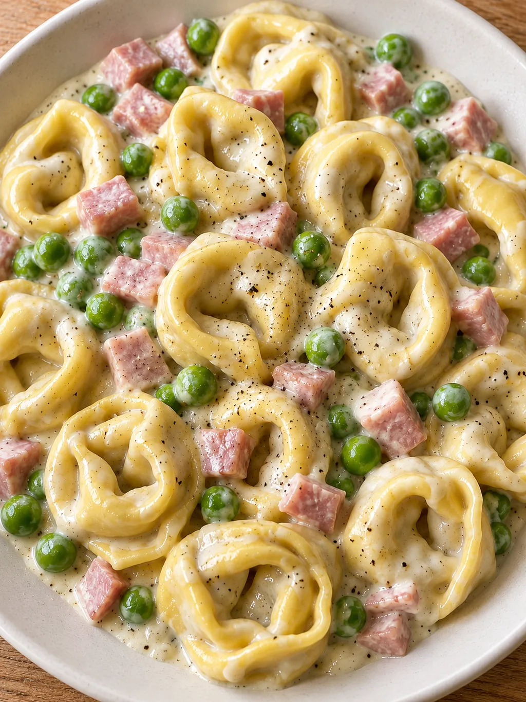 Käsetortellini mit Schinken, Erbsen und cremiger Parmesan-Sahnesoße